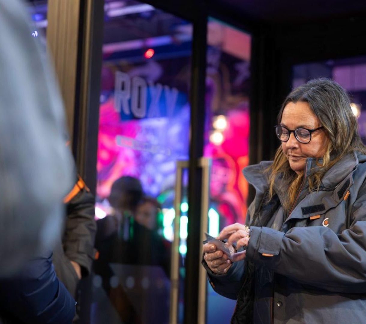 Female door supervisor checking an ID